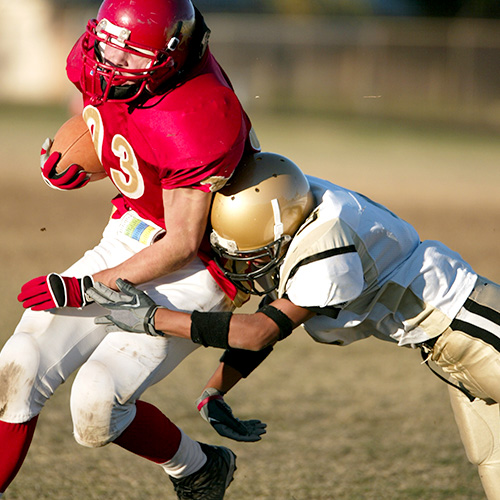 Body tackle during football game between players.