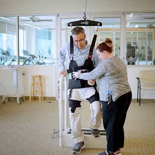 CNS patient with therapist using the ZeroG to navigate steps. 