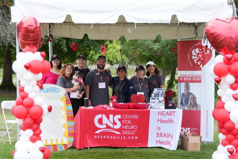 Colorful outdoor booth at a brain injury awareness event, promoting neuro skills and heart-brain health.